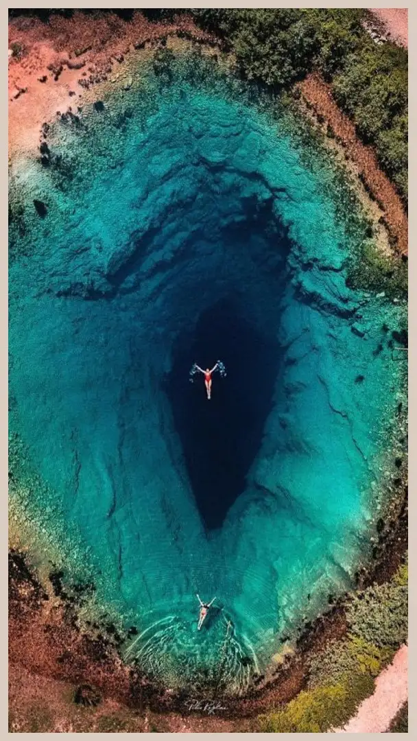 Aerial view of people swimming in the Eye of the Earth spring, Croatia.