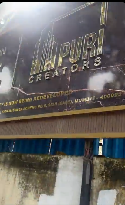 Frame from a user-supplied video showing a Puri Creators sign above blue construction barricades.